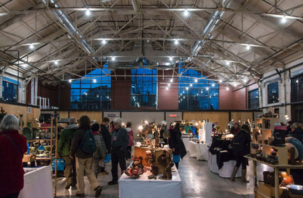 Image of the inside of the Horticulture building with a flea market going on