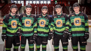 Image of five 67's wearing the green St. Patty's Day jerseys