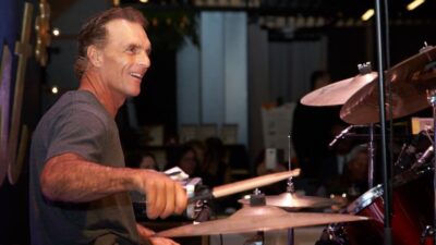 Image of former CFL quarterback Doug Flutie playing drums